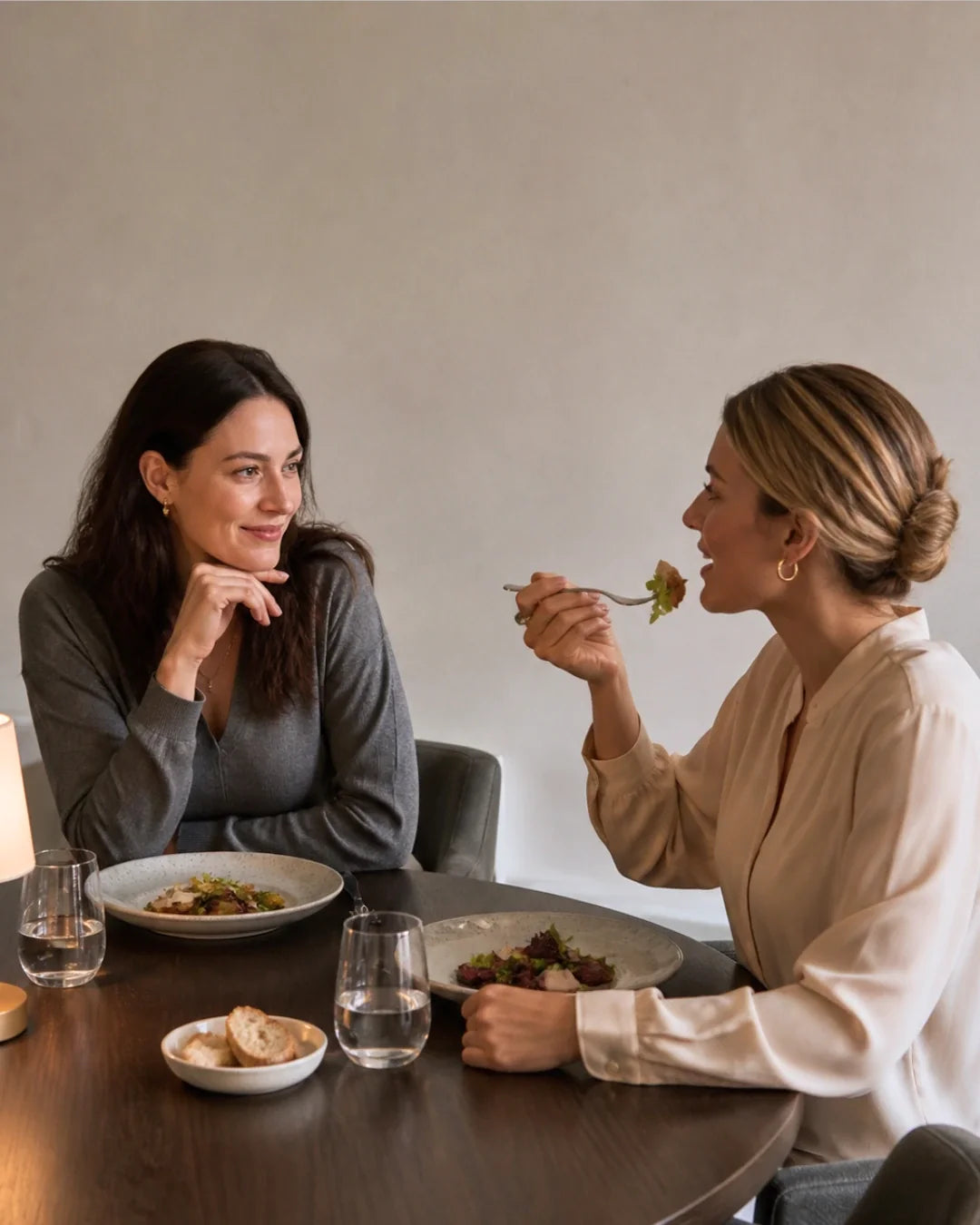 Women in elegant everyday outfits enjoying dinner together, showcasing underwear comfort from desk to dinner
