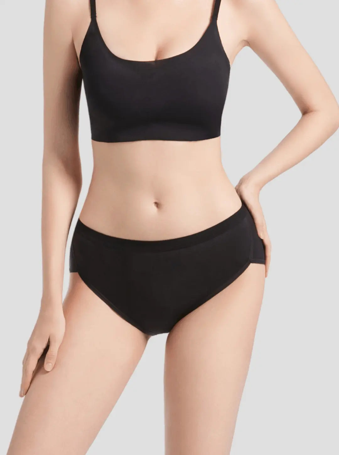 Woman wearing black NuCycle Leak Proof Brief and matching black top, full-coverage cotton underwear with built-in leak-proof lining for period protection